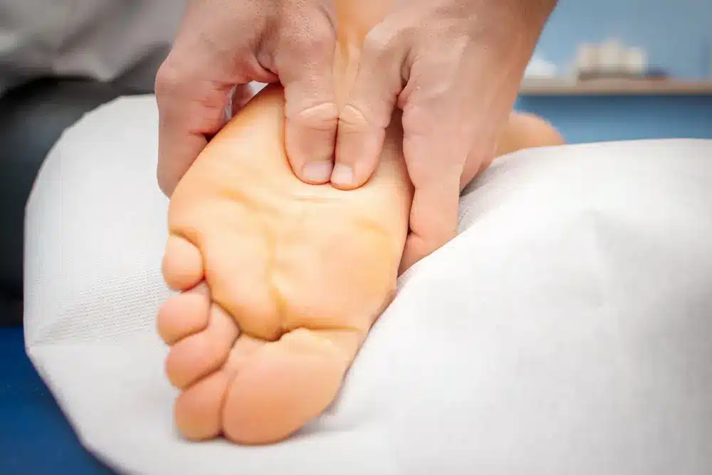 un terapeut care aplica reflexoterapie unui pacient cu migrena