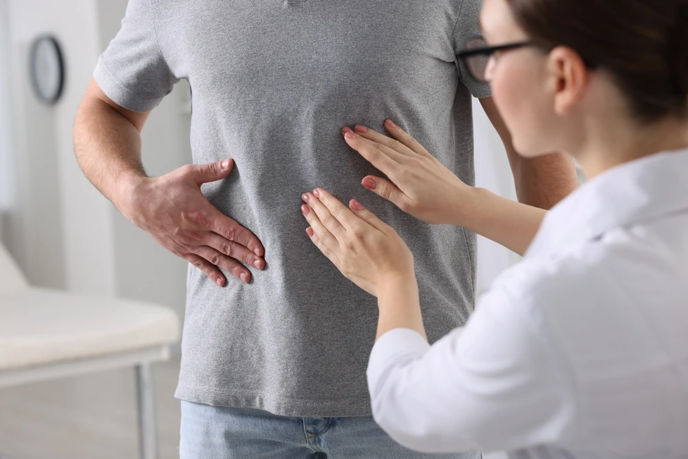 un medic gastroenterolog care examinează un pacient