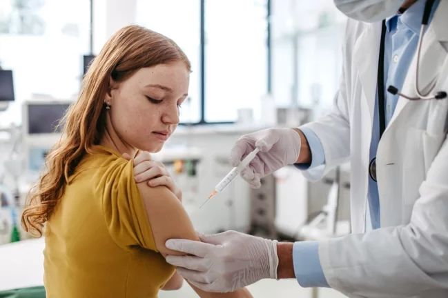 Medic administrează un vaccin anti-HPV