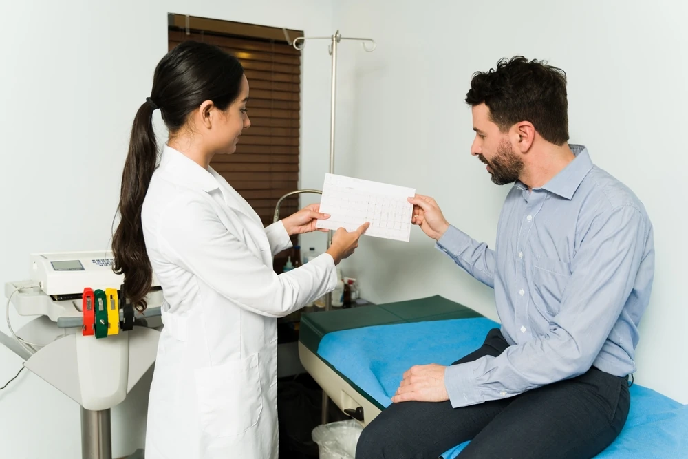 Medic cardiolog care explică rezultatele electrocardiogramei unui pacient